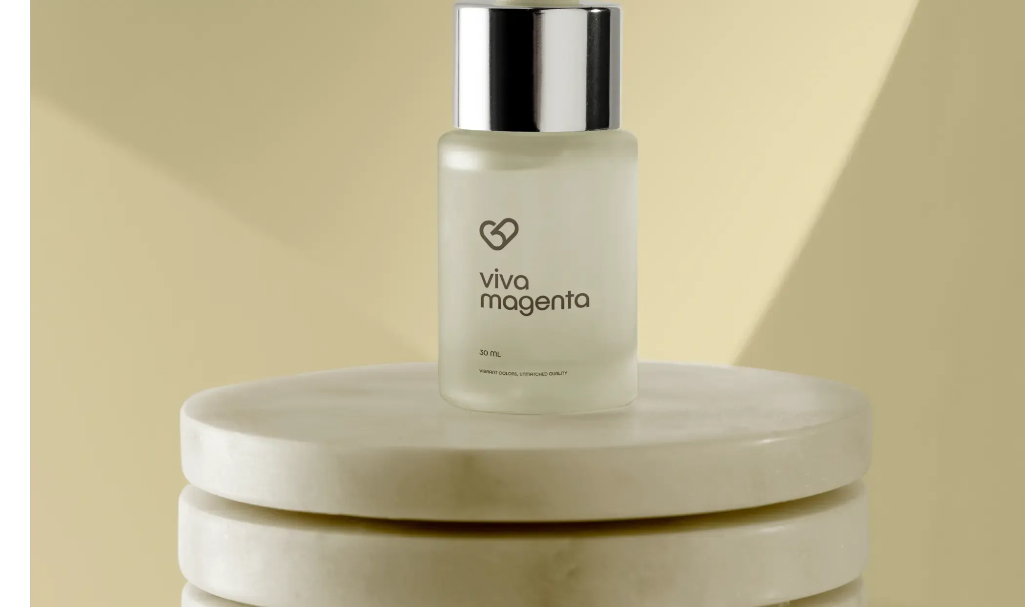 Frosted glass cosmetic bottle with a clear label on a stone plinth