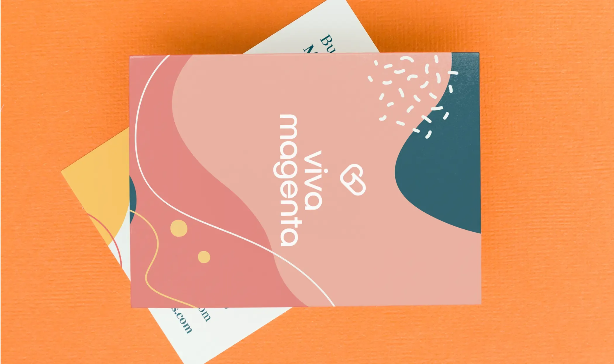 Abstract-patterned Viva Magenta cards on an orange background